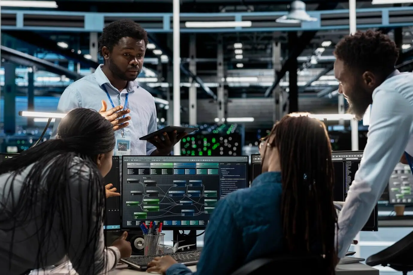 Инженеры проводят мозговой штурм по программированию в серверной ферме.